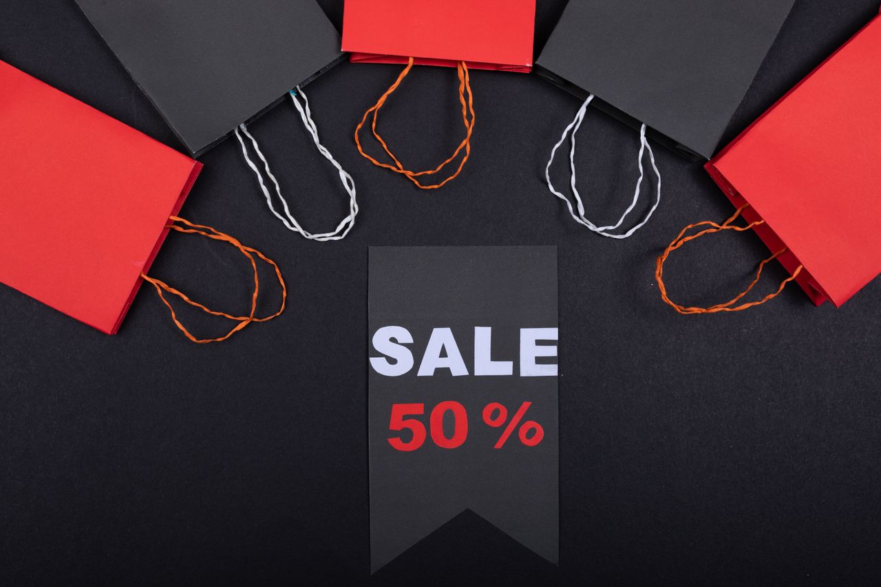 A "Sale 50%" tag laid out among shopping bags
